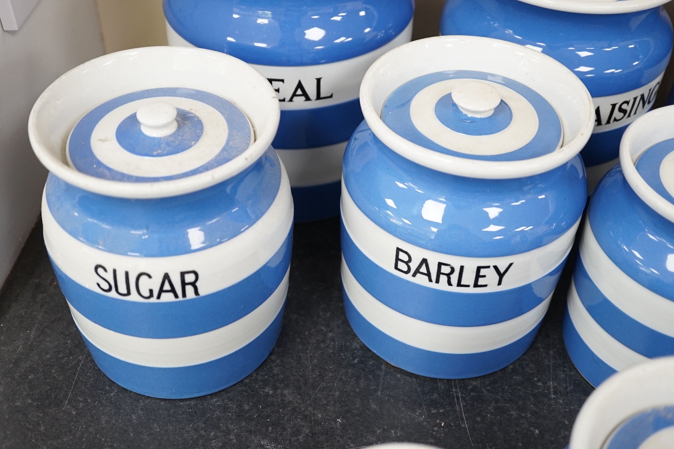 T.G.Green Cornish Kitchenware, eleven lidded storage jars to include Oatmeal, Self Raising Flour, Tapioca, Barley Flour, Granulated Sugar and Sago, largest 19cm high, Green Church marks. Condition - fair and good